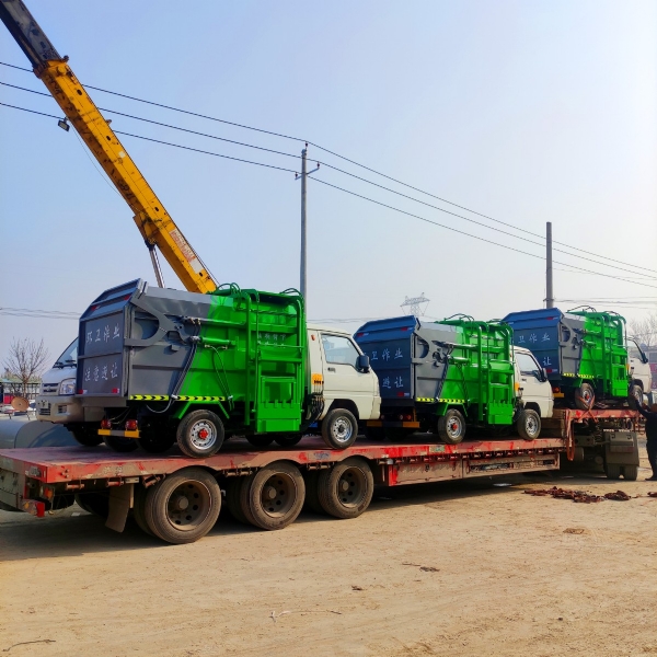 十二輛掛桶垃圾車(chē)裝車(chē)中，準(zhǔn)備發(fā)往哈爾濱